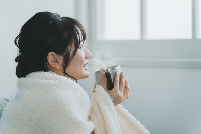 ホットドリンクで温まる女性