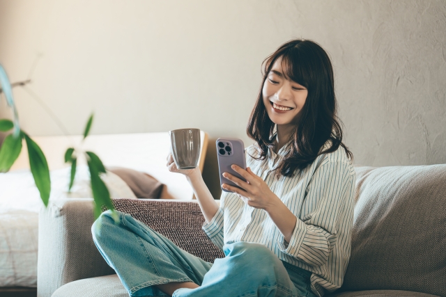 リビングでドリンクを飲みながらくつろぐ女性